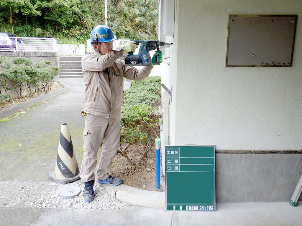 給水施設改修工事にて外壁にアンカーを打つスタッフ